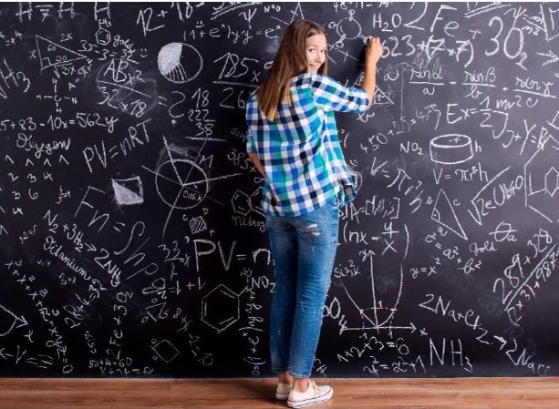 alumna escrivint a la pissarra de classe